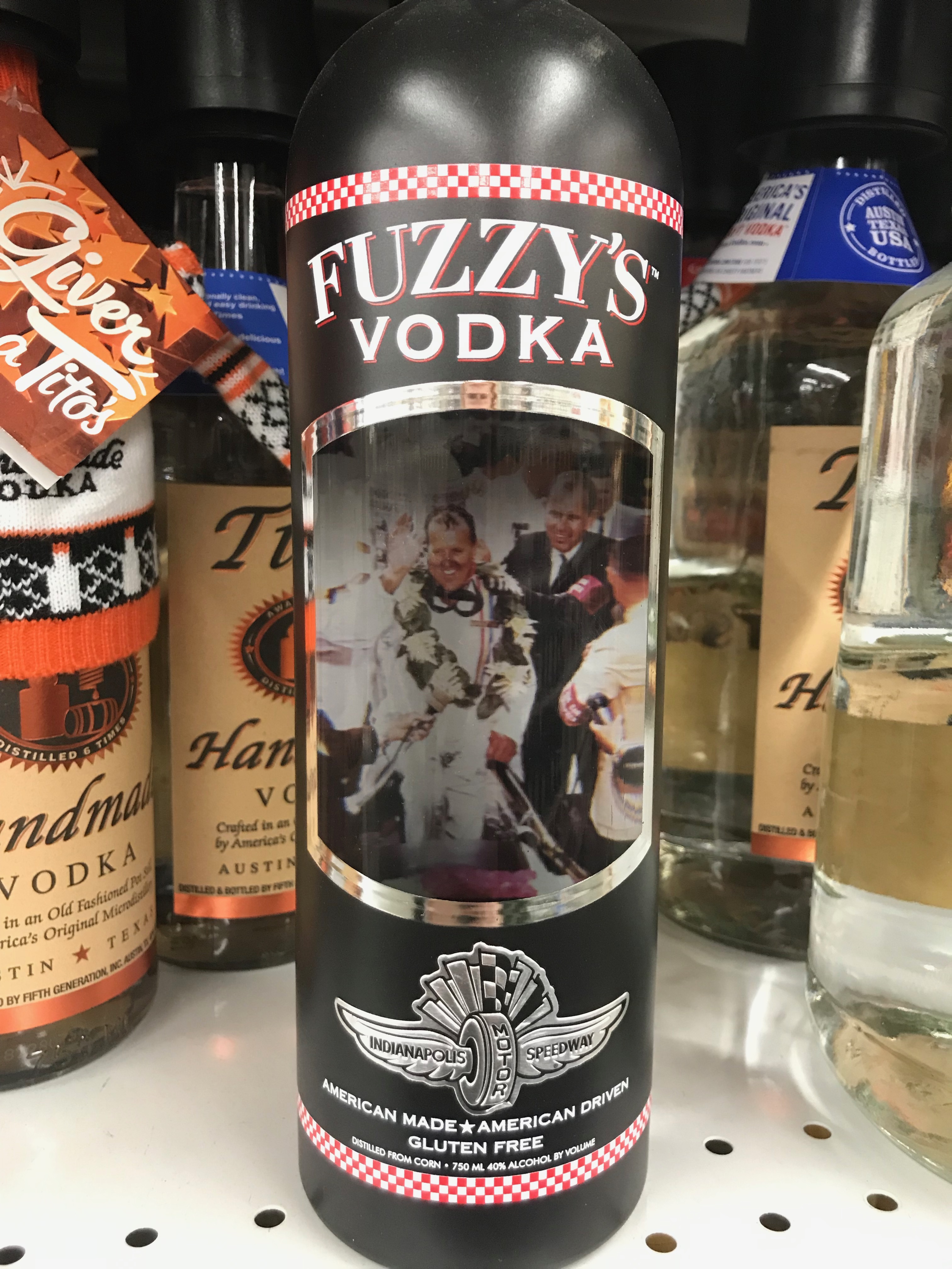 Shelf in store with Vodka bottles, bottle in center is Fuzzy's Vodka