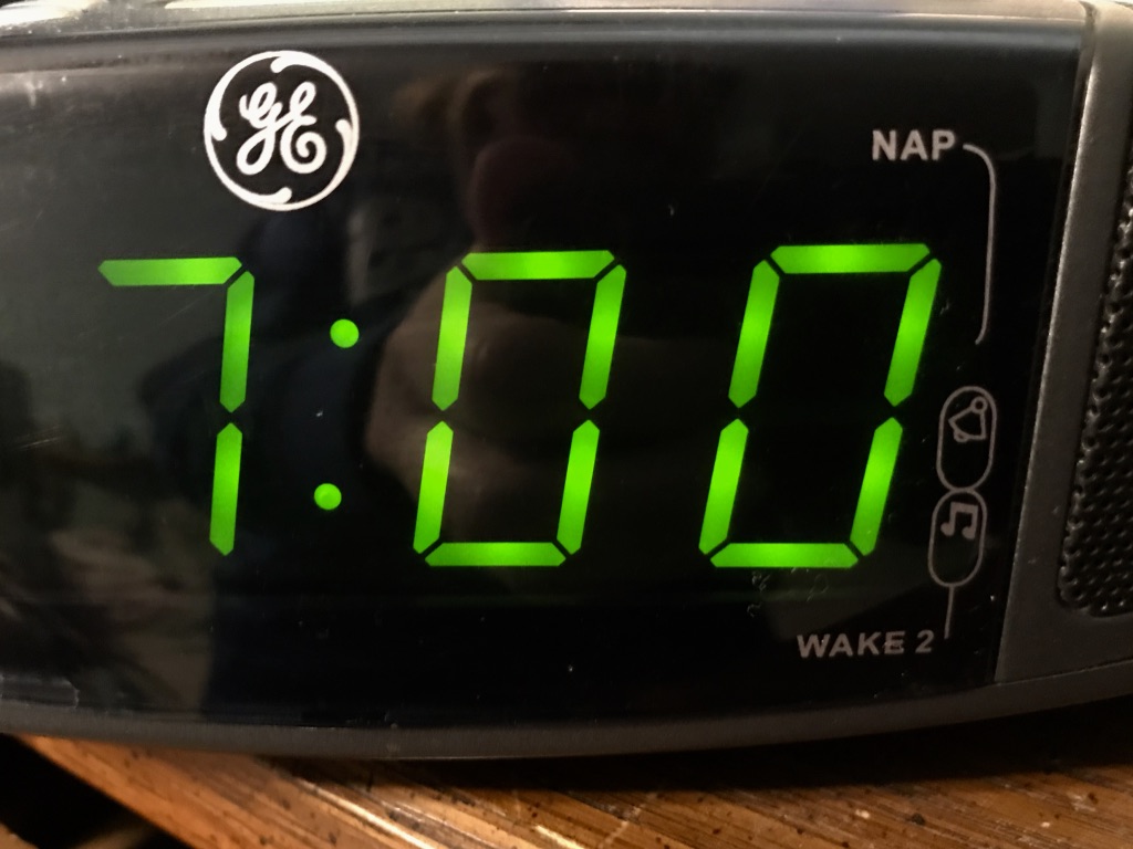 Close up of a digital clock showing 7:00pm time