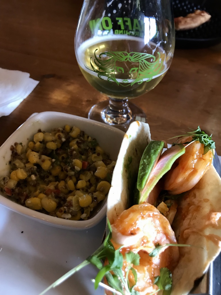 Shrimp taco with corn salsa and a beer