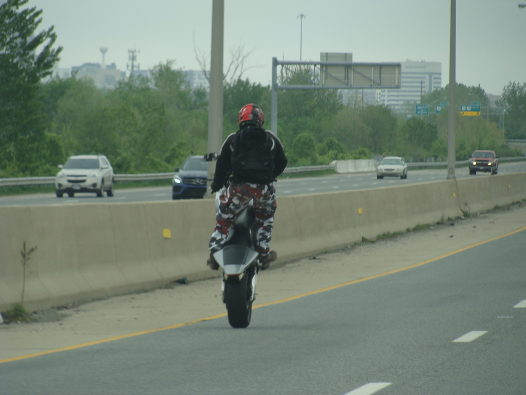 Guy on motorcycle doing a rear wheelie.