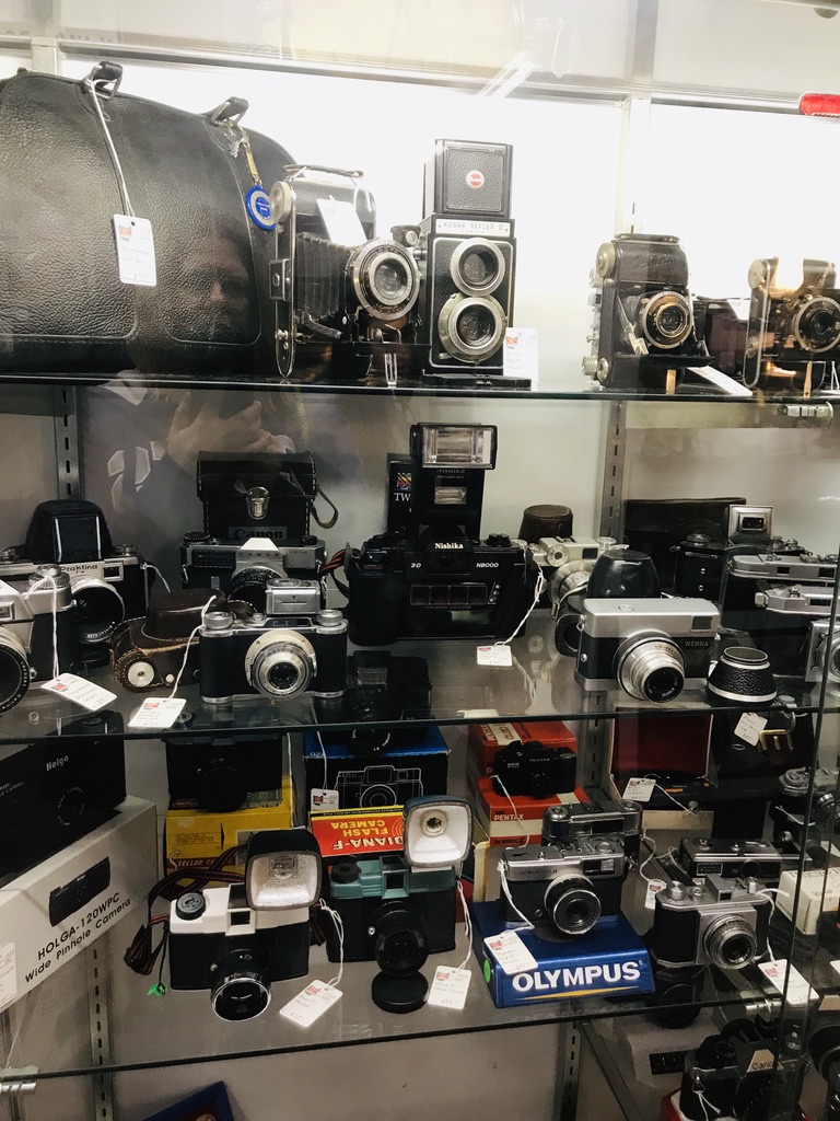 Glass cabinet full of old cameras.