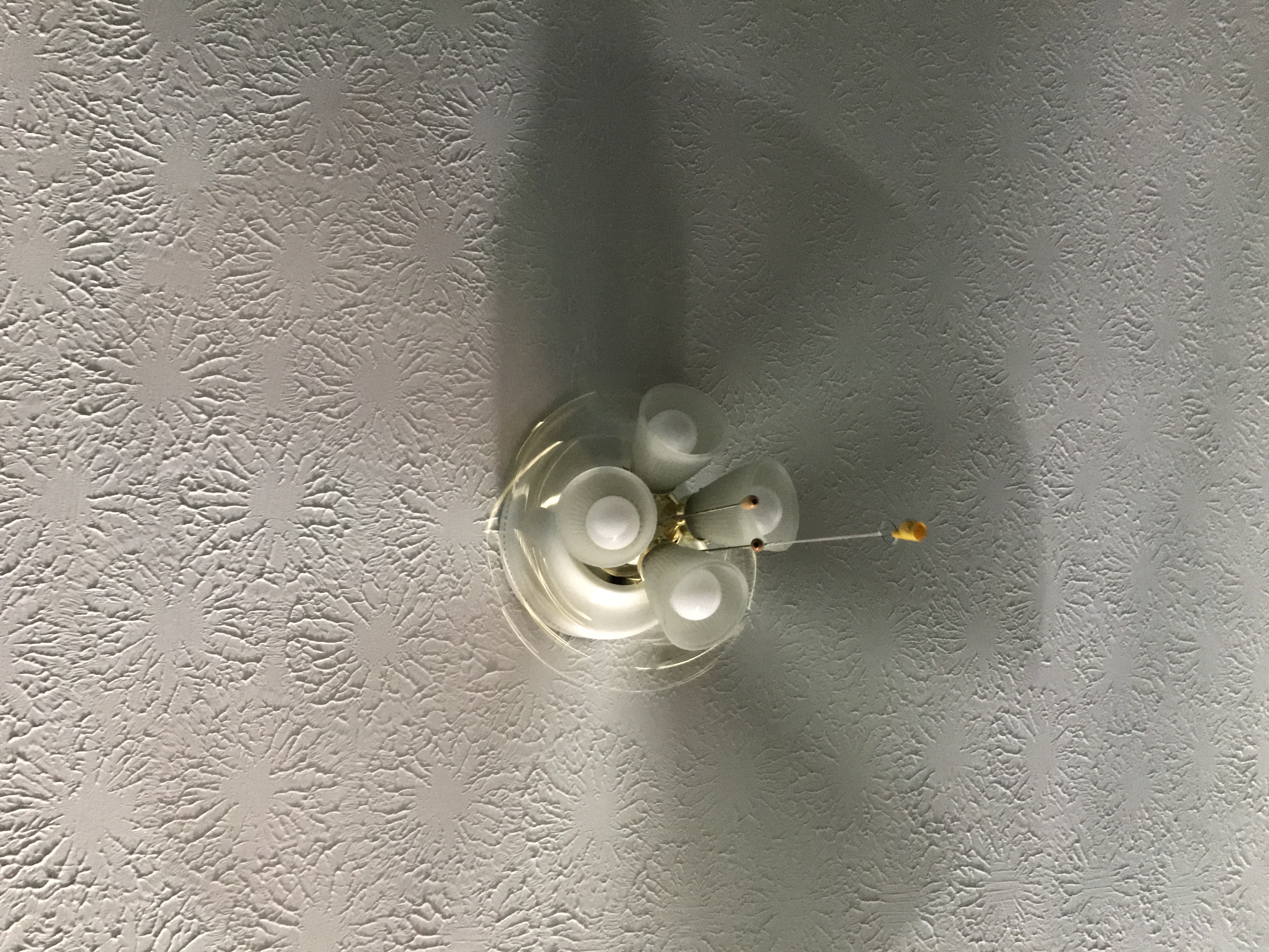 2 Photos of a ceiling fan, one with light on and one with light off.