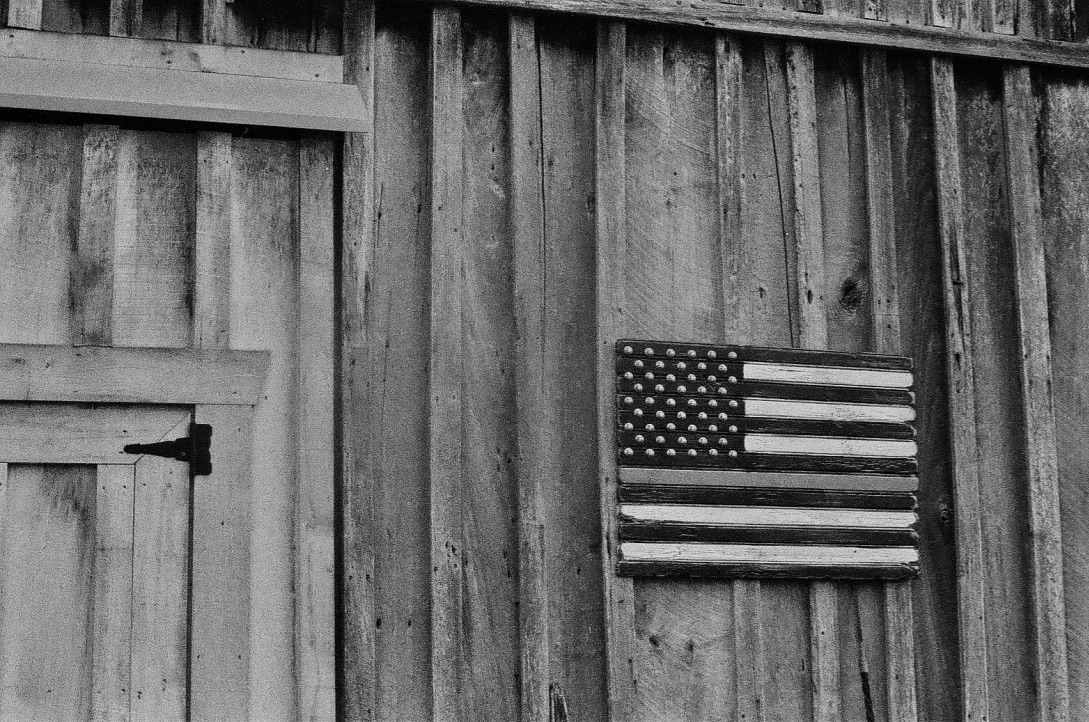 black and white American flag on side of a barn