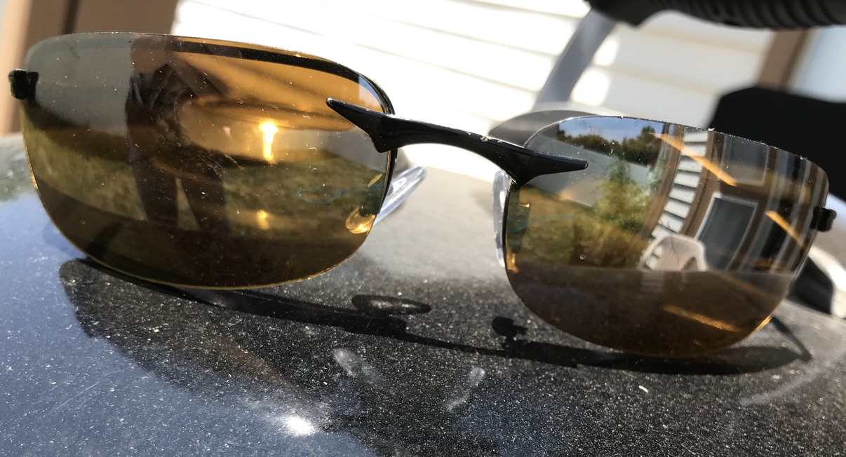 Sunglasses with reflection of a house and person in it