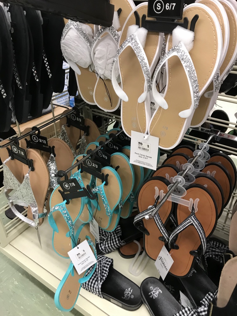 Flip flops hanging on pegs in a store.