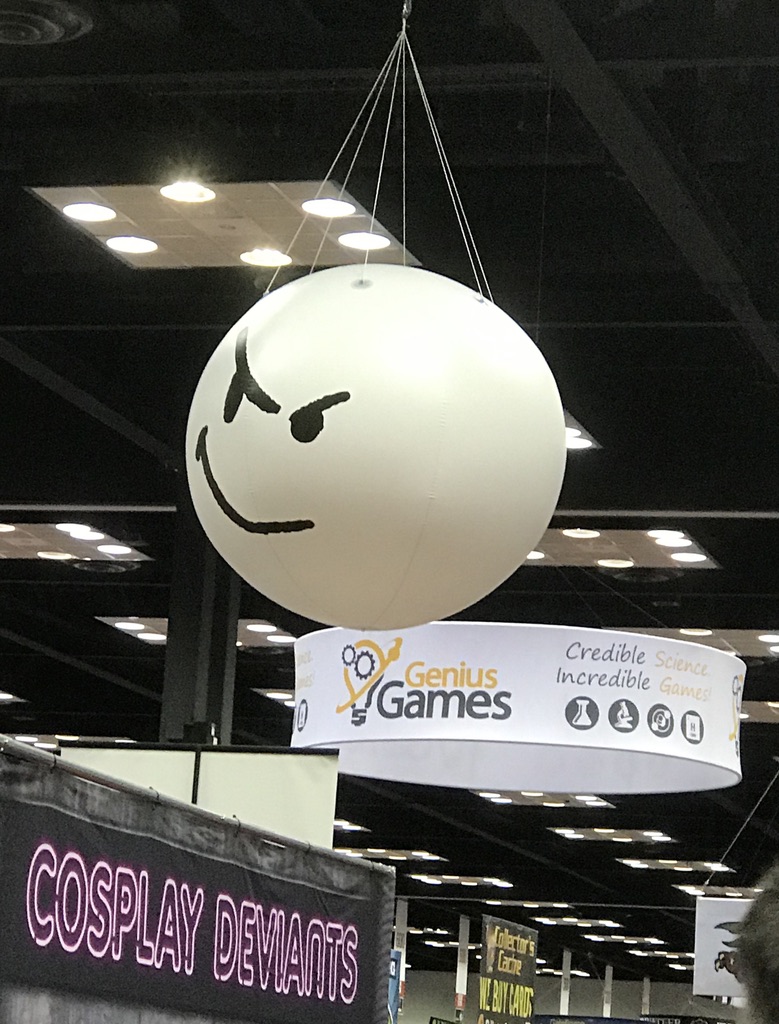 A big round ball with a face painted on it hanging from the ceiling.