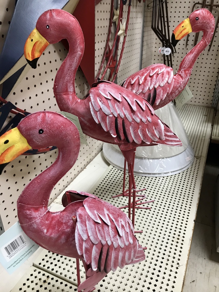 A row of metal yard flamingos 